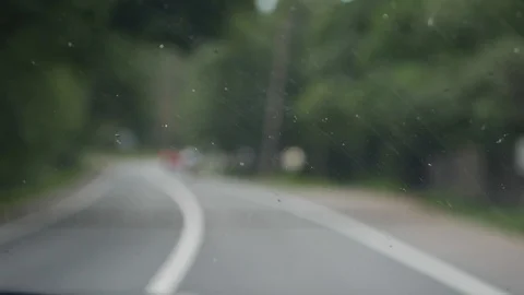 Wipers clean the windshield of the car on the go. Inside blurred view of a Stock Footage 103413207
