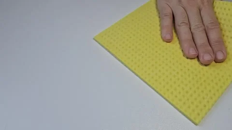 Wiping clean table surface with a yellow sponge cloth indoors Stock Footage 341676781