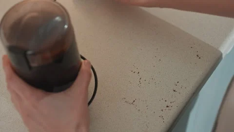 Wiping scattered coffee grounds from kitchen surface. Quickly tidying up coffee Stock Footage 342072979