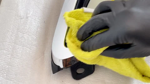 Wiping water-drop-like cleaning solution from chrome car grille Stock Footage 311679644