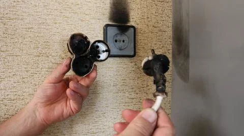 Wire and socket burnt out due to overload of electrical network Stock Photos