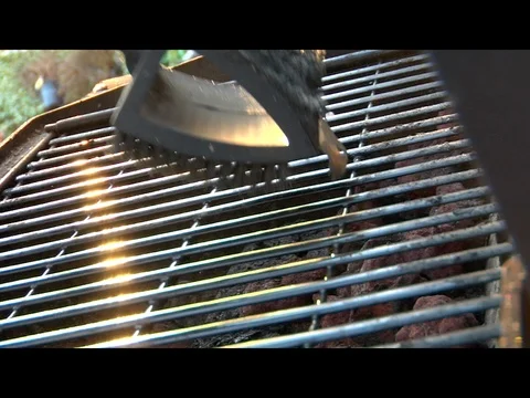 Wire brush scrubbing cleaning grill grates on dirty barbecue A Video stock 125489554