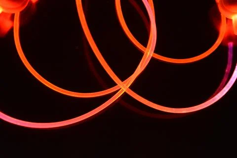 Wire, cable, polyethylene tubes, rods with red, orange, yellow, pink light. Stock Photos