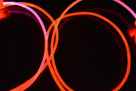 Wire, cable, polyethylene tubes, rods with red, orange, yellow, pink light. Stock Photos