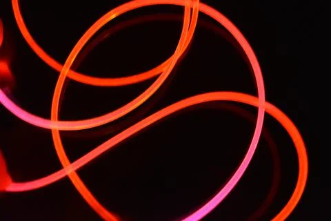 Wire, cable, polyethylene tubes, rods with red, orange, yellow, pink light. Stock Photos