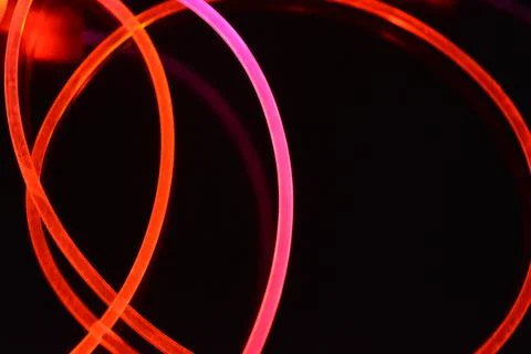 Wire, cable, polyethylene tubes, rods with red, orange, yellow, pink light. Stock Photos
