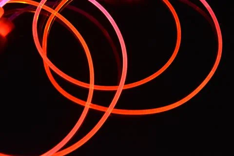 Wire, cable, polyethylene tubes, rods with red, orange, yellow, pink light. Stock Photos