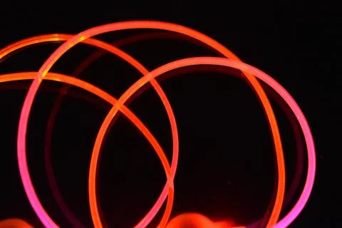 Wire, cable, polyethylene tubes, rods with red, orange, yellow, pink light. Stock Photos