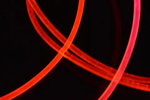 Wire, cable, polyethylene tubes, rods with red, orange, yellow, pink light. Stock Photos