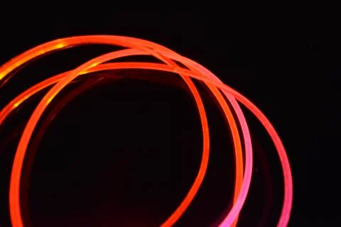 Wire, cable, polyethylene tubes, rods with red, orange, yellow, pink light. Stock Photos