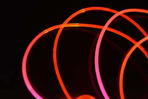 Wire, cable, polyethylene tubes, rods with red, orange, yellow, pink light. Stock Photos