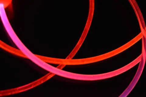 Wire, cable, polyethylene tubes, rods with red, orange, yellow, pink light. Stock Photos