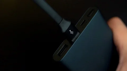 The wire for charging the phone connects to a portable of a power bank Stock Footage 105969760
