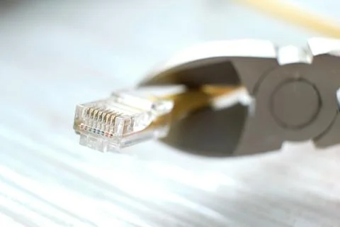 Wire cutters cutting internet cable. Connection plugs and wires on old wooden 写真素材