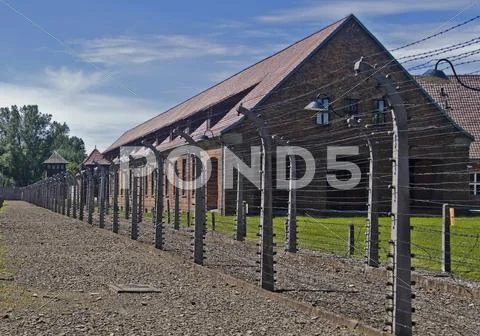 Wire fence and barrack in a uschwitz - birkenau concentration camp Stock Photos
