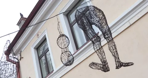 Wire human figures hanging above Uzupis street facade Stock Footage 321048430
