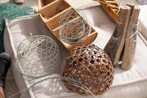 Wire mesh and woven dome traps sit near miniature dhow model. traditional g.. Stock Photos