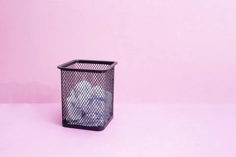 Wire mesh garbage basket with square profile on two toned pink background Stock Photos