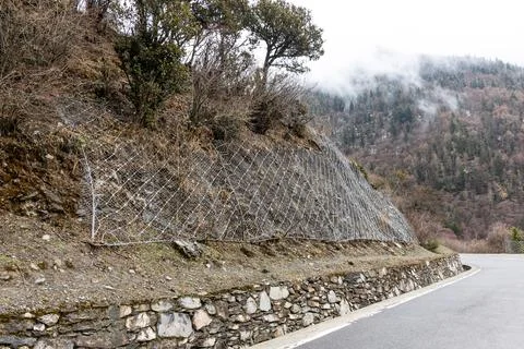 Wire mesh grid installed on slope to stabalize the soil and prevent landslide in Stock Photos