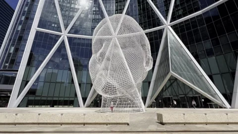 Wire mesh sculpture of head in front of modern glass building, calgary Stock Footage 302572464