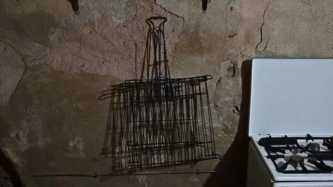 Wire rack casting a moving shadow on a rustic wall Video stock 320407462