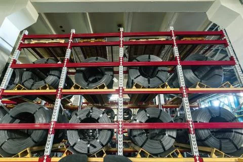 Wire spools lie on multi-tiered racks. Stock Photos