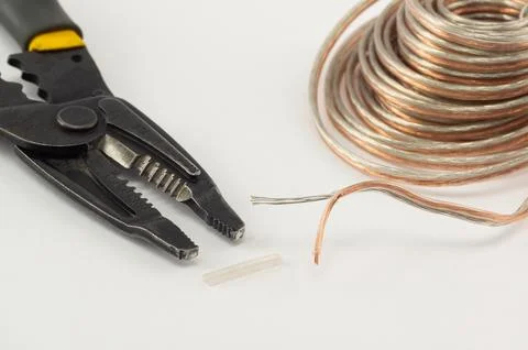 Wire stripper tool and transparent copper speaker cable close-up Foto stock
