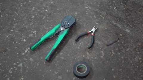 A wire stripper tool side cutters and insulating tape on floor. Stock Footage 345913296