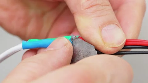 Wire stripping. the process of removing the insulation or outer layer of wire Stock Footage 246983100