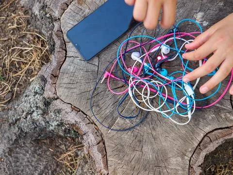 Wired in-ear headset bundle tangled in a messy knot. Stock Photos