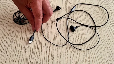 Wired Earphones and USB-C Headphones Displayed on Wooden Table Stock Footage 339847029