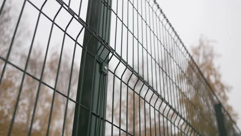 Wired fence shows structured pattern near football field Stock Footage 308959302