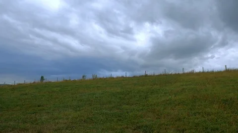 Wired garden fence on the top of the hill, dramatic stormclouds Stock Footage 116156341