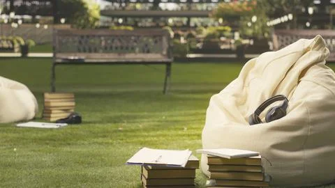 Wireless audio headset placed on fabric beanbag in outdoors space Stock Photos