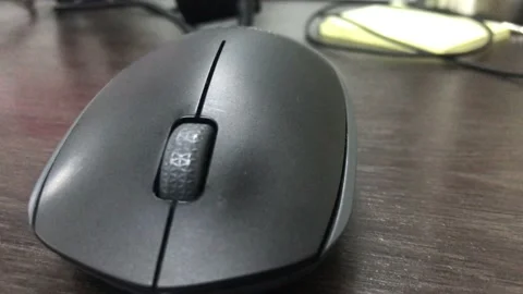 Wireless black color mouse connected wirelessly to the laptop Stockbeeldmateriaal 169136580