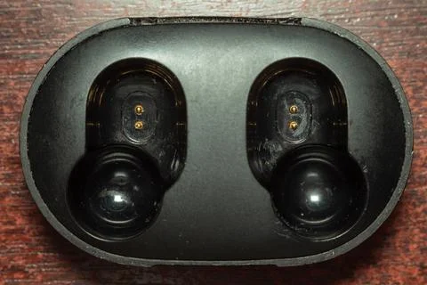 Wireless bluetooth earbuds in a black charging case. Russia - 02 August 2026 Stock Photos