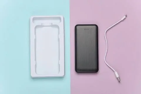Wireless charger with cable and empty case on pastel background Stock Photos