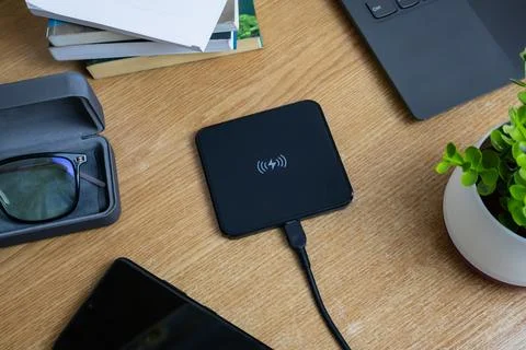 Wireless charging pad on work table Stock Photos