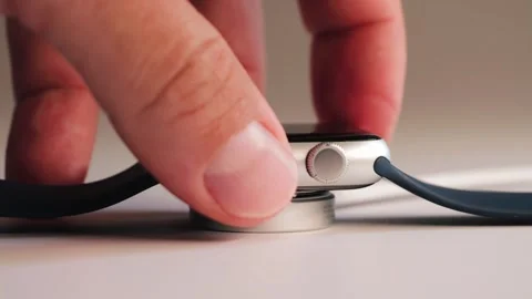 Wireless charging smartwatch. Close-up of smartwatch charging with wireless Vídeos de archivo 316031142