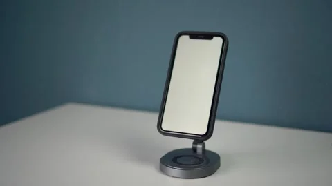 Wireless charging stand for phone with elegant modern design. Phone with white Stock Footage 314465457