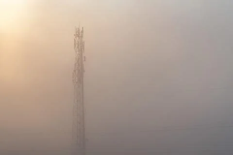 Wireless communication mobile cell network tower surrounded by thick fog. Zer Stock Photos