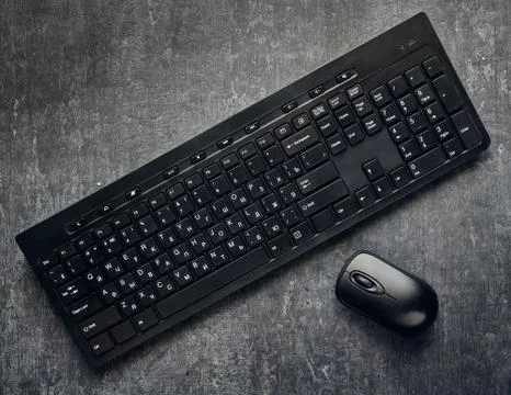 Wireless computer keyboard and mouse on gray background, close up, are styliz Stock Photos