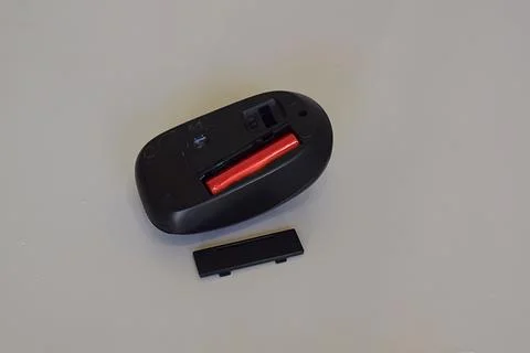 Wireless computer mouse and battery. Stock Photos