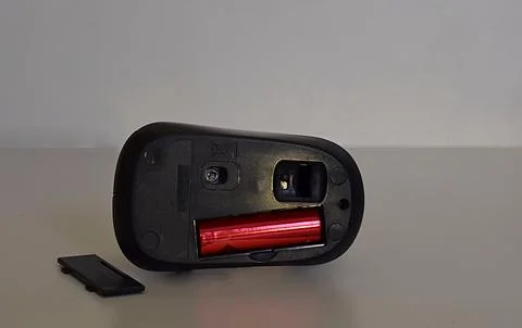 Wireless computer mouse and battery. Stock Photos