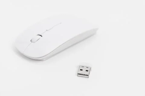 Wireless computer mouse and USB receiver on a white surface Stock Photos