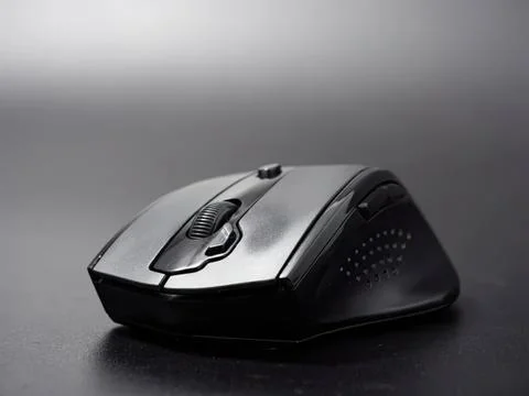 Wireless computer mouse on black surface in close-up Stock Photos