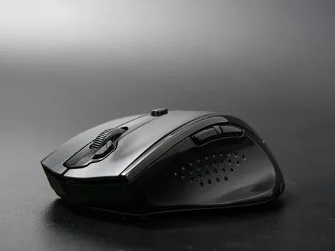 Wireless computer mouse on dark surface Stock Photos