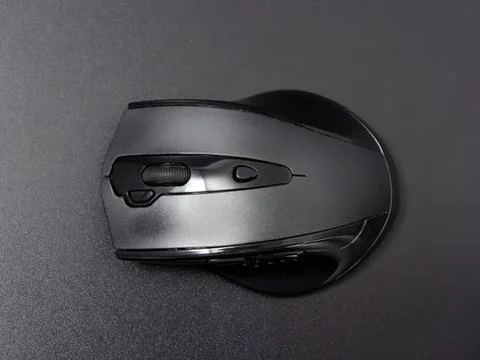 Wireless computer mouse on dark surface for office work Stockfoto's