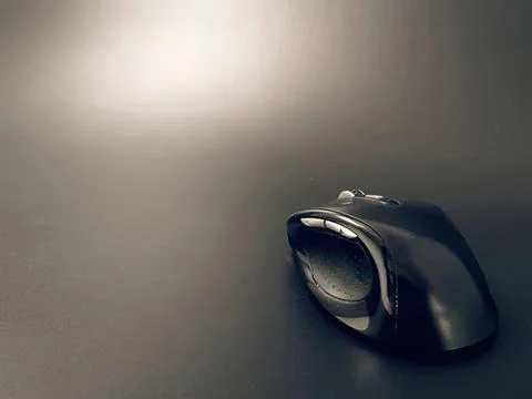 Wireless computer mouse on dark surface with shadow Stock Photos