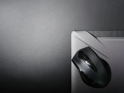 Wireless computer mouse on a desk with a laptop Stock Photos